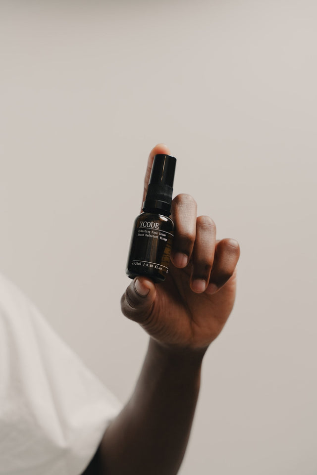 Hand holding YCODE Hydrating Face Serum, formulated with Chlorella vulgaris microalgae extract