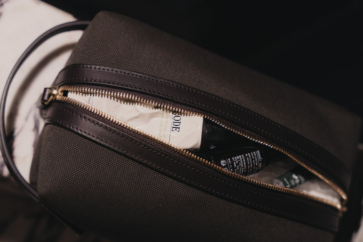 A wash bag half unzipped with the YCODE Mattifying Moisturiser, Hydrating Face Serum and Advanced Eye Serum packed inside