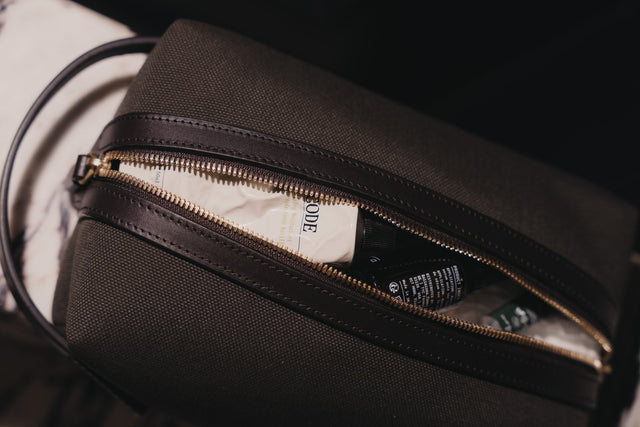 A wash bag half unzipped with the YCODE Mattifying Moisturiser, Hydrating Face Serum and Advanced Eye Serum packed inside