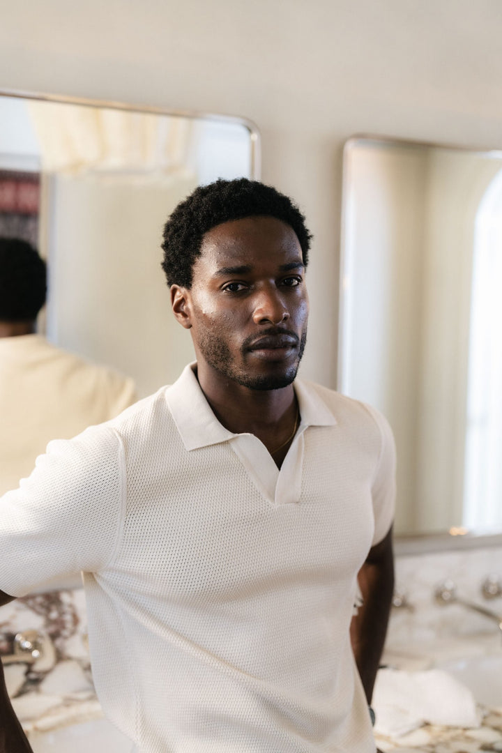 A man in a bathroom mirror during his morning routine