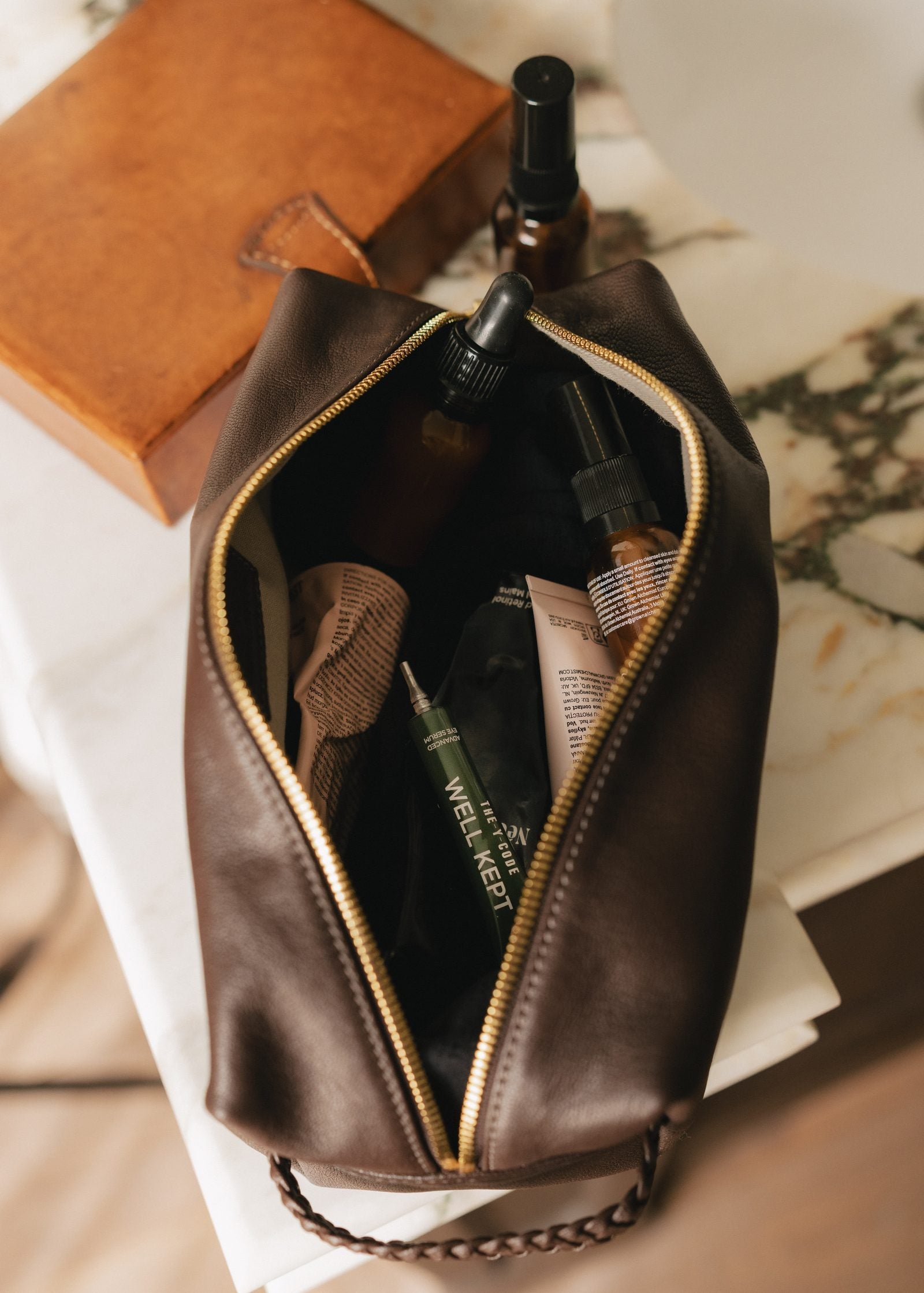 A YCODE washbag and travel case on a bed