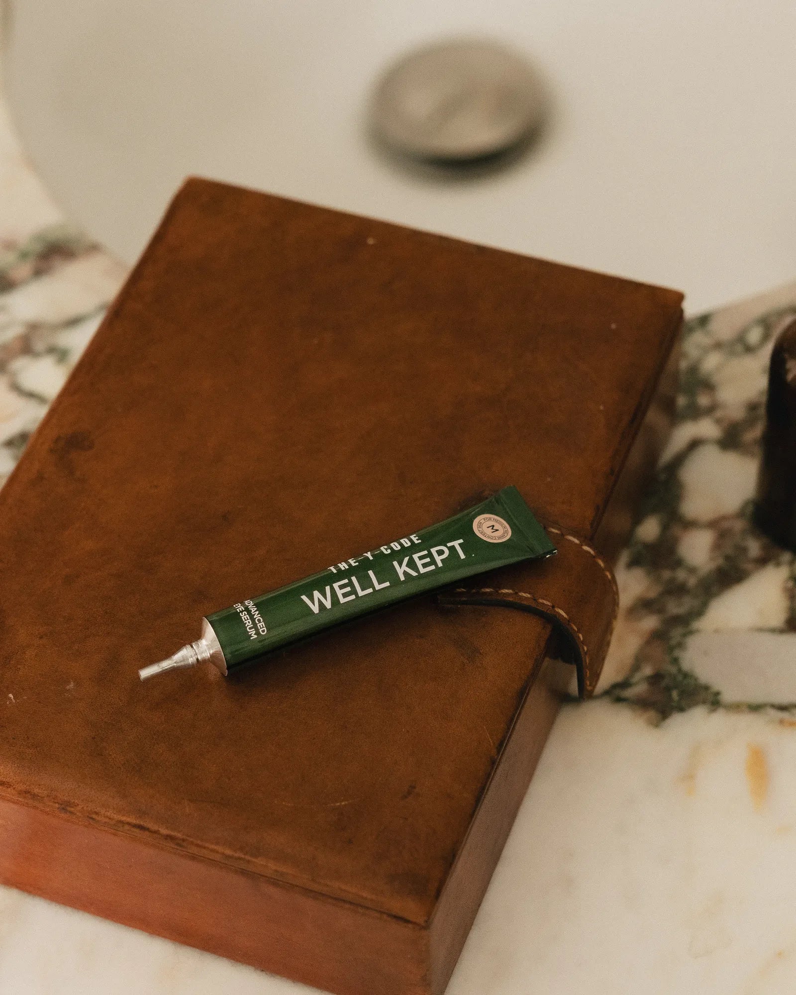 Advanced Eye Serum resting on a leather journal
