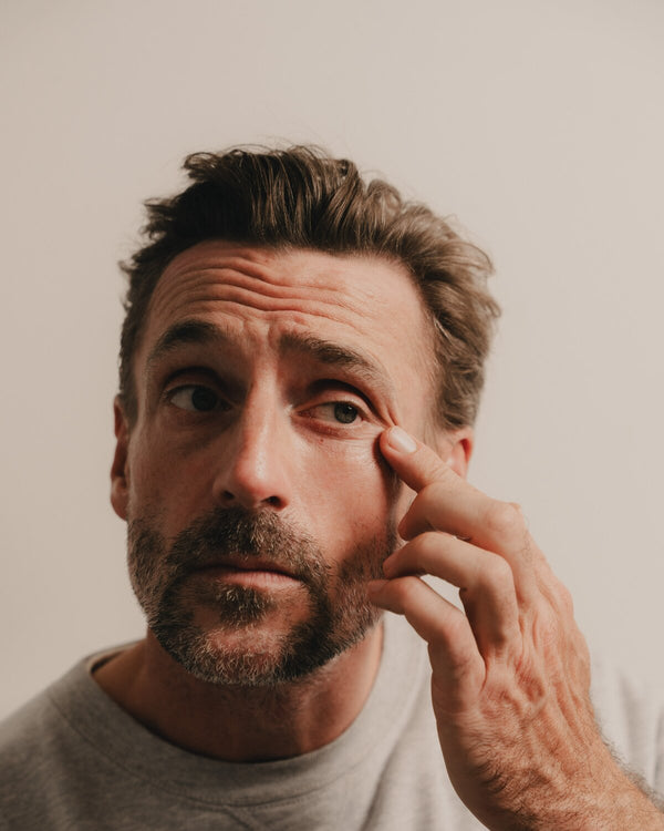A man applying the Advanced Eye Serum under the eye